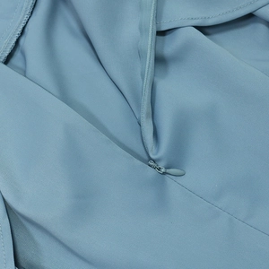 Gros plan du tissu de robe bleu clair avec détail de fermeture éclair invisible