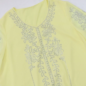 Detailed view of rhinestone leaf patterns on a yellow V-neck chiffon dress gown