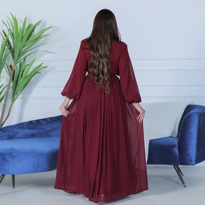 Detail of burgundy gown showing elegant long lantern sleeves and fluid maxi skirt flow