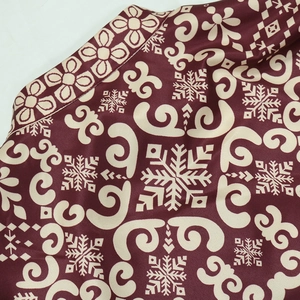 Detail of dark red Jalabiya fabric featuring cream floral patterns and satin texture