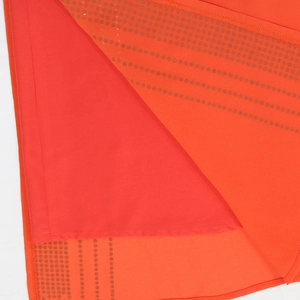 Dettaglio di tessuto a rete rossa con texture a puntini e fodera liscia per abito