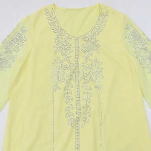 Detail of V-neck light yellow chiffon dress with silver rhinestone leaf patterns