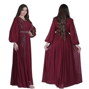 Detail of burgundy long-sleeve evening gown featuring intricate silver sequins and beading