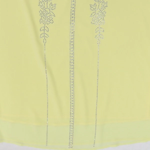Detail of light yellow chiffon dress with silver rhinestone floral patterns and vertical lines