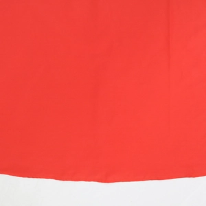 Dettaglio del tessuto rosso acceso dell'abito con cuciture dell'orlo e trama liscia fine