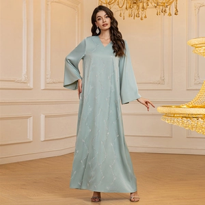 Detail of light green satin dress with sparkling rhinestone wave patterns and flare sleeves