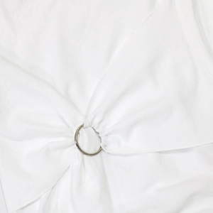 Detailed close-up of white dress fabric gathered by a polished silver O-ring metal buckle