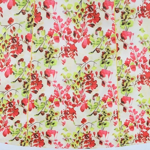 Detailed view of floral print fabric with red and yellow petals and yellow piping stitch