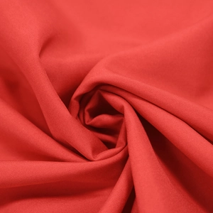 Texture dettagliata del tessuto rosso con elegante motivo a spirale per abiti moda