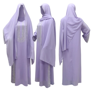 Dettaglio dell'abaya musulmana viola chiaro con strass argentati su polsini e sull'orlo