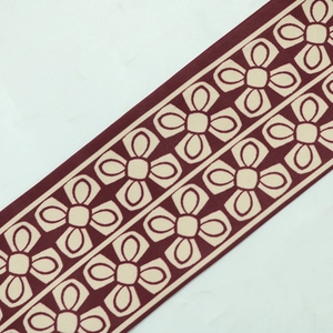 Close-up of burgundy and beige floral geometric trim detailing on the jalabiya dress