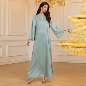Detailed view of luxury satin fabric with silver rhinestone branch patterns on long gown