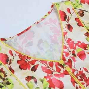 Close-up of V-neckline with yellow piping and buttons on floral print dress