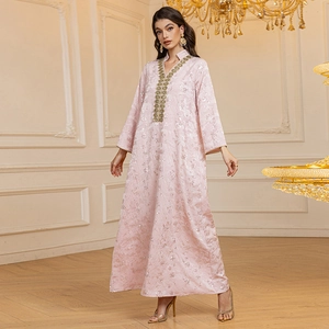 Détail d'une robe Abaya rose pâle avec broderie de paillettes dorées et jacquard fleuri