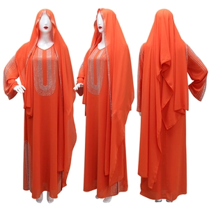 Dettaglio dell'abaya arancione con strass argentati e hijab coordinato incluso