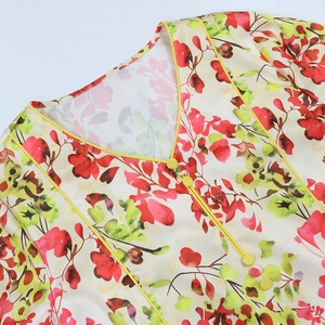 Close-up of V-neck floral blouse with yellow piping and three decorative buttons