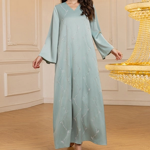 Detail of light green satin gown showing elegant V-neckline and sparkling rhinestone patterns