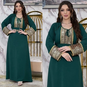 Detail of sequin-braided trim and lace on dark green Jalabiya evening dress