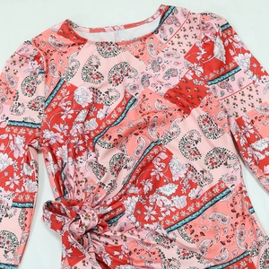Detail view of the pink paisley floral print and waist tie on the long sleeve dress