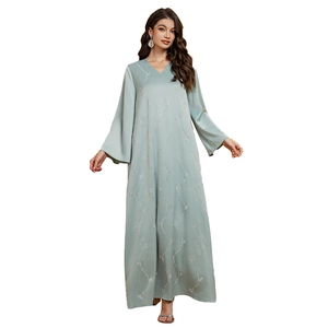 Close-up of elegant sage green satin robe featuring silver sequin wavy patterns and bell sleeves