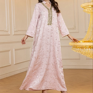 Détails de paillettes roses et broderies dorées sur l'encolure d'une robe élégante