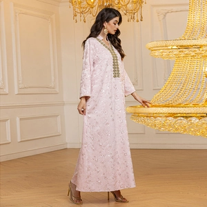 Détail du caftan rose avec motifs floraux en paillettes de luxe et dentelle dorée