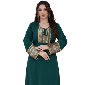Close-up of golden sequins and lace embroidery on a dark green jalabiya dress