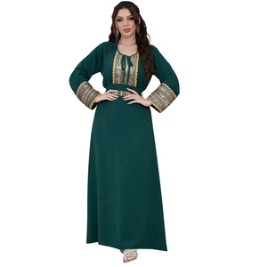 Detail of gold sequin embroidery and lace trim on dark green jalabiya evening dress