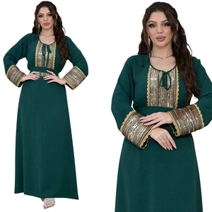 Close-up of deep green jalabiya kaftan with intricate gold and silver sequin embroidery