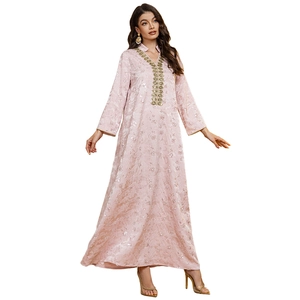 Détail d'un caftan rose avec broderie de paillettes dorées et manches longues élégantes