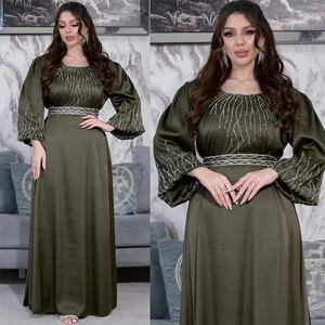 Détails des broderies de perles argentées et paillettes sur la robe en satin vert