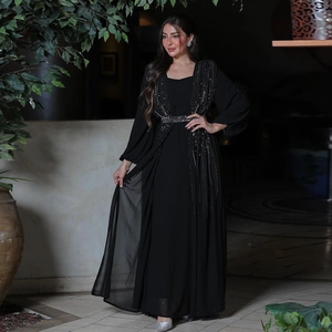 Detail of elegant black rhinestone evening gown with shimmering belt and long sleeves