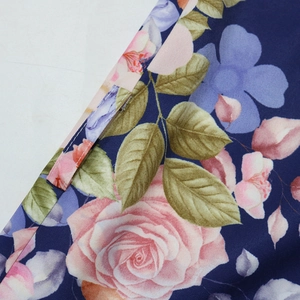 Dettaglio della stampa floreale rosa su tessuto blu scuro con cucitura del passante per cintura