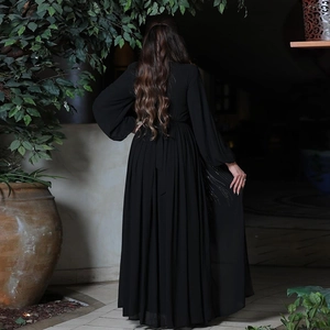 Detailed back view of pleated black maxi dress with elegant sequin embellishments