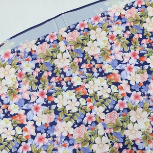 Dettaglio del tessuto floreale con rose rosa e cuciture rifinite sul bordo del vestito