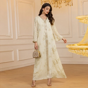 Detail of elegant cream caftan with gold floral embroidery and matching handbag