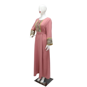 Detail of jalabiya dress with sequined neckline and lace-up tassel details in dusty pink
