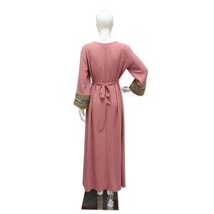 Back view of pink Jalabiya dress with sequin trim cuffs and tied waist belt