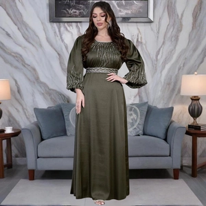 Détail d'une robe en satin vert olive avec des motifs en perles argentées et ceinture