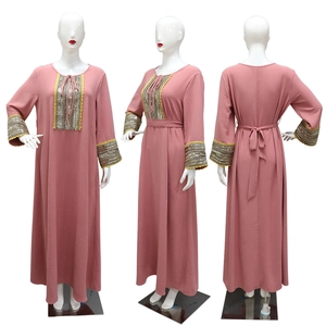 Detail of jalabiya dress showing sequin embroidery and lace trim on pink fabric