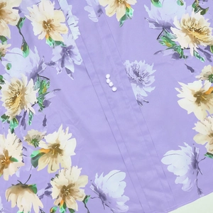 Dettaglio vestito floreale viola con pieghe verticali e bottoni di perle eleganti