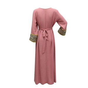 Detail of dusty rose Jalabiya dress showing the waist tie and sequin cuffs on back view