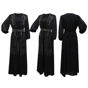 Detail of black long-sleeved abaya dress featuring radial rhinestone waist embellishments