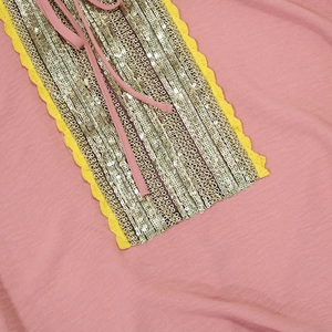Detail of pink Jalabiya dress featuring gold sequins, yellow lace, and neck ties