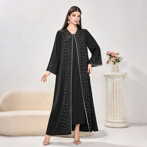 Detailed view of black abaya featuring white circular patterns and silver trimmed cuffs