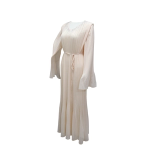 Détail de la robe de soirée rose clair plissée avec col en strass et manches cape