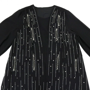 Detailed view of black chiffon robe featuring vertical silver beading and white pearl accents