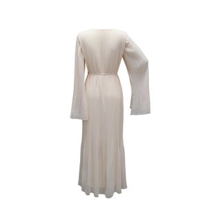 Détail d'une robe longue plissée élégante avec manches évasées et ceinture assortie