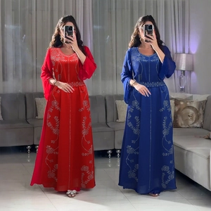Détail de broderie florale sur une robe caftan élégante à manches longues rouge et bleue