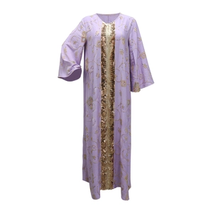 Macro view of golden sequins and ethnic embroidery on a light purple kaftan dress